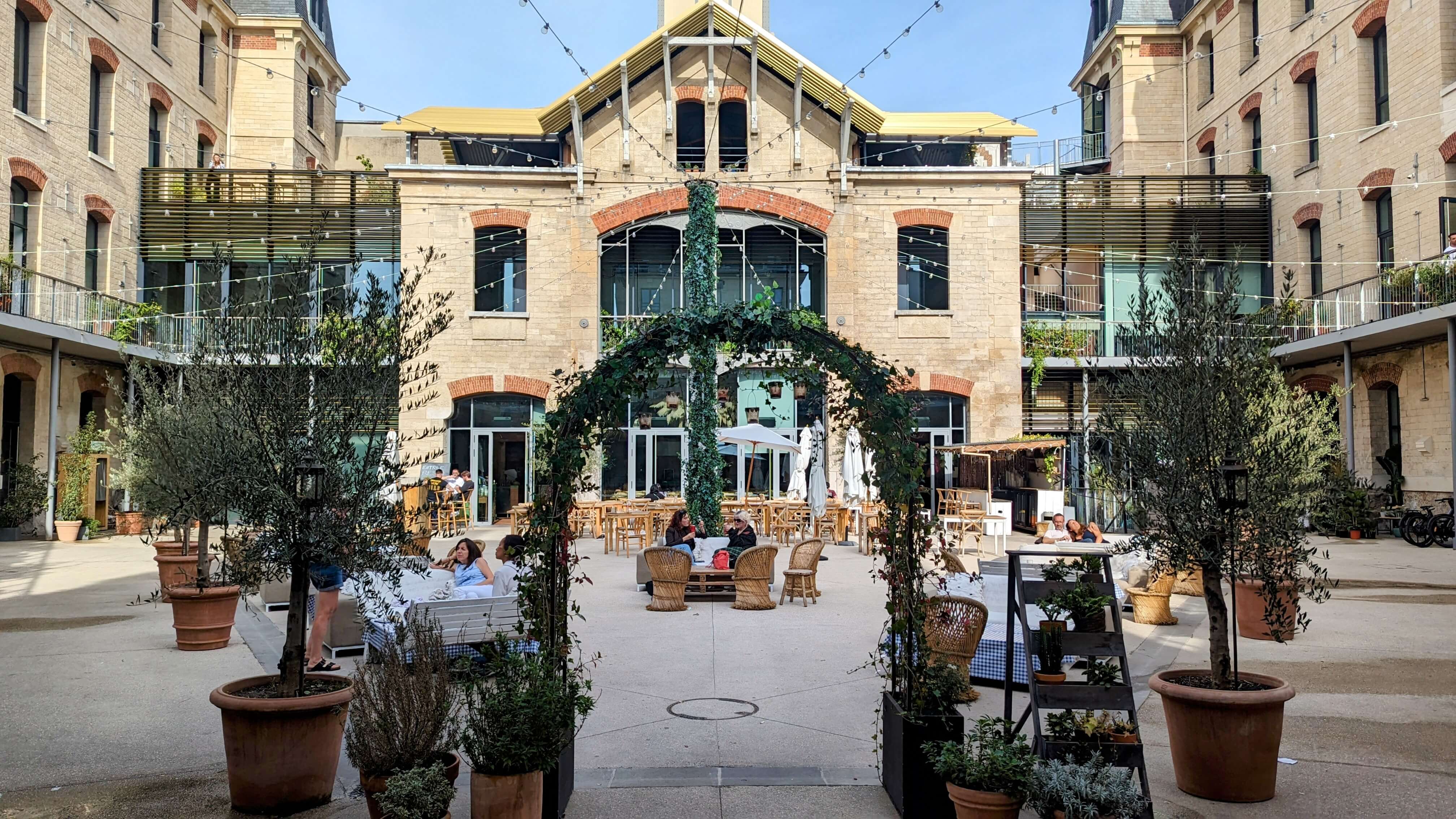 Parisians are enjoying a coffee in the sun of eco-friendly fashion hub La Caserne's terrace in Paris.