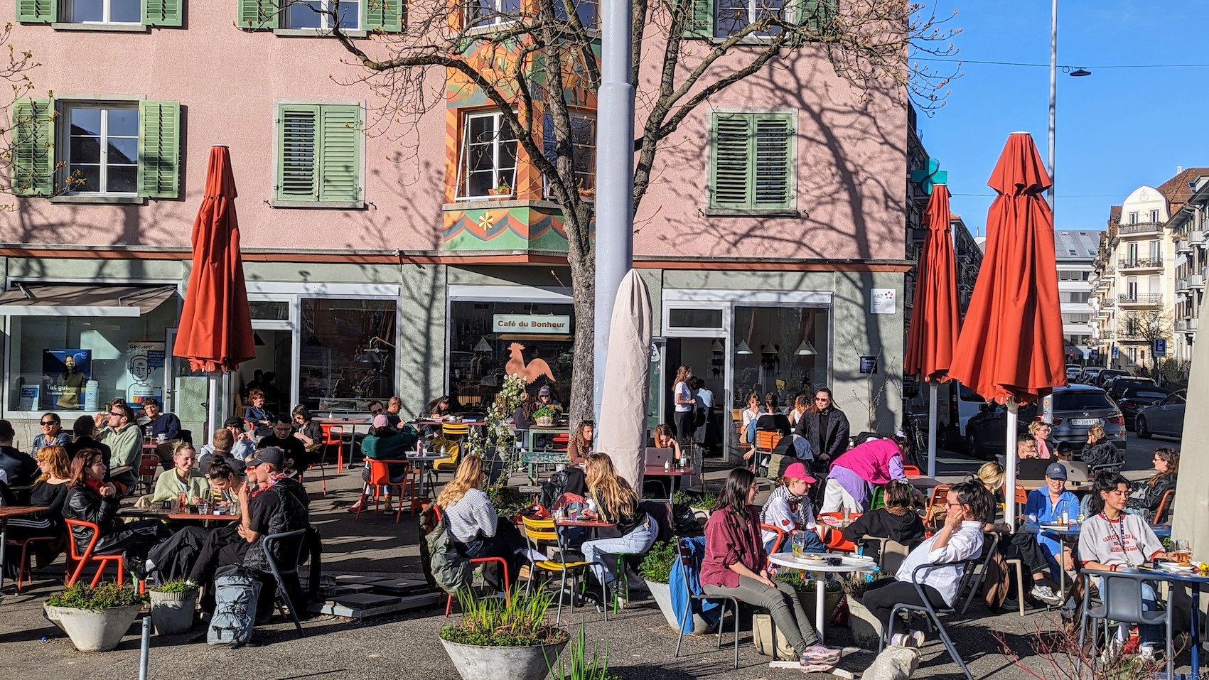 The sunny terrace of the Café du Bonheur in Zurich is packed with guests.