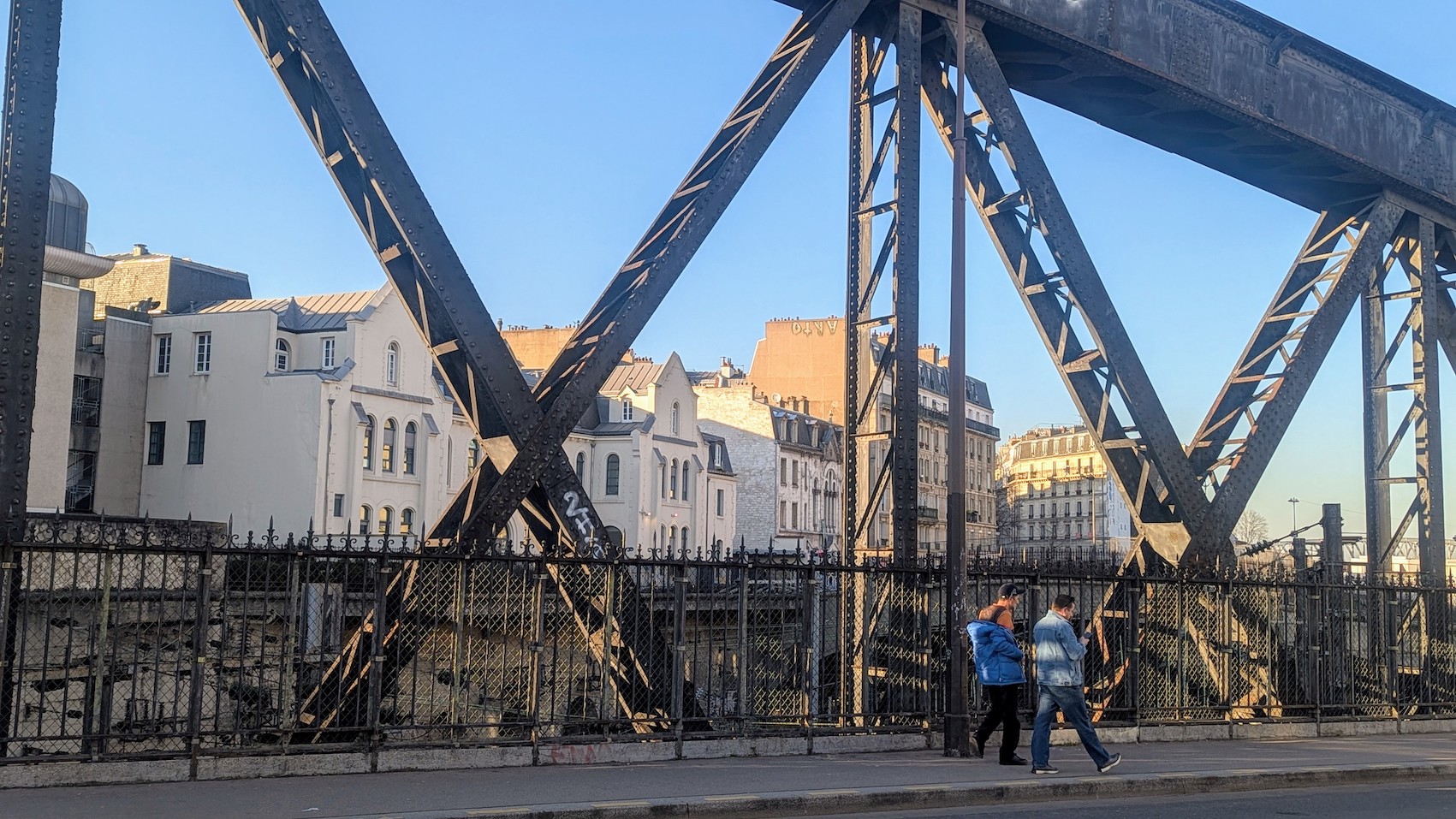 Pedestrians crossing the bridge on Rue La Fayette in Paris's 10th arrondissement.