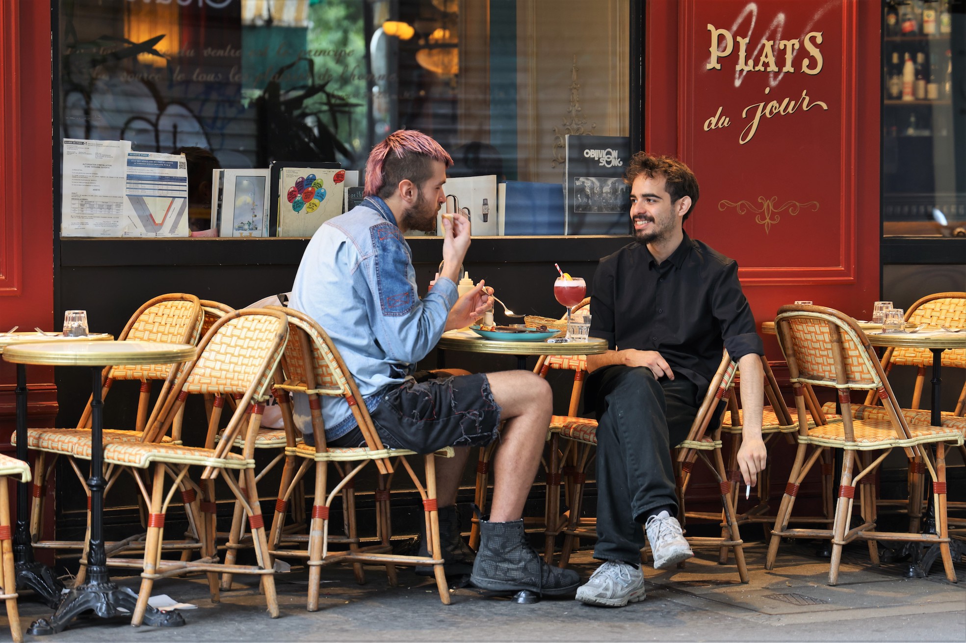 Two Parisians having drinks and food at a café in the trendy 10th arrondissement in Paris.