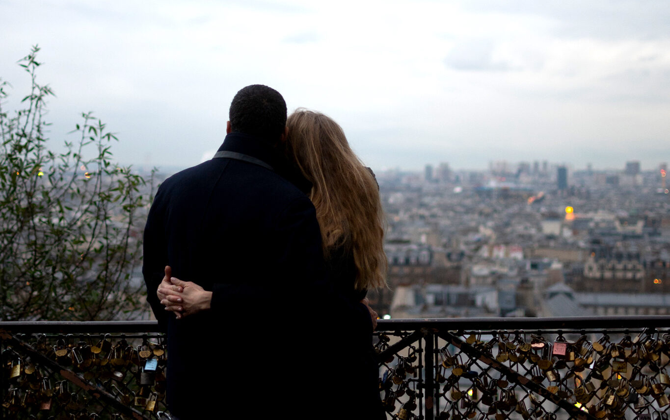 A couple sharing an intimate moment while enjoying the view on Paris from Montmartre.