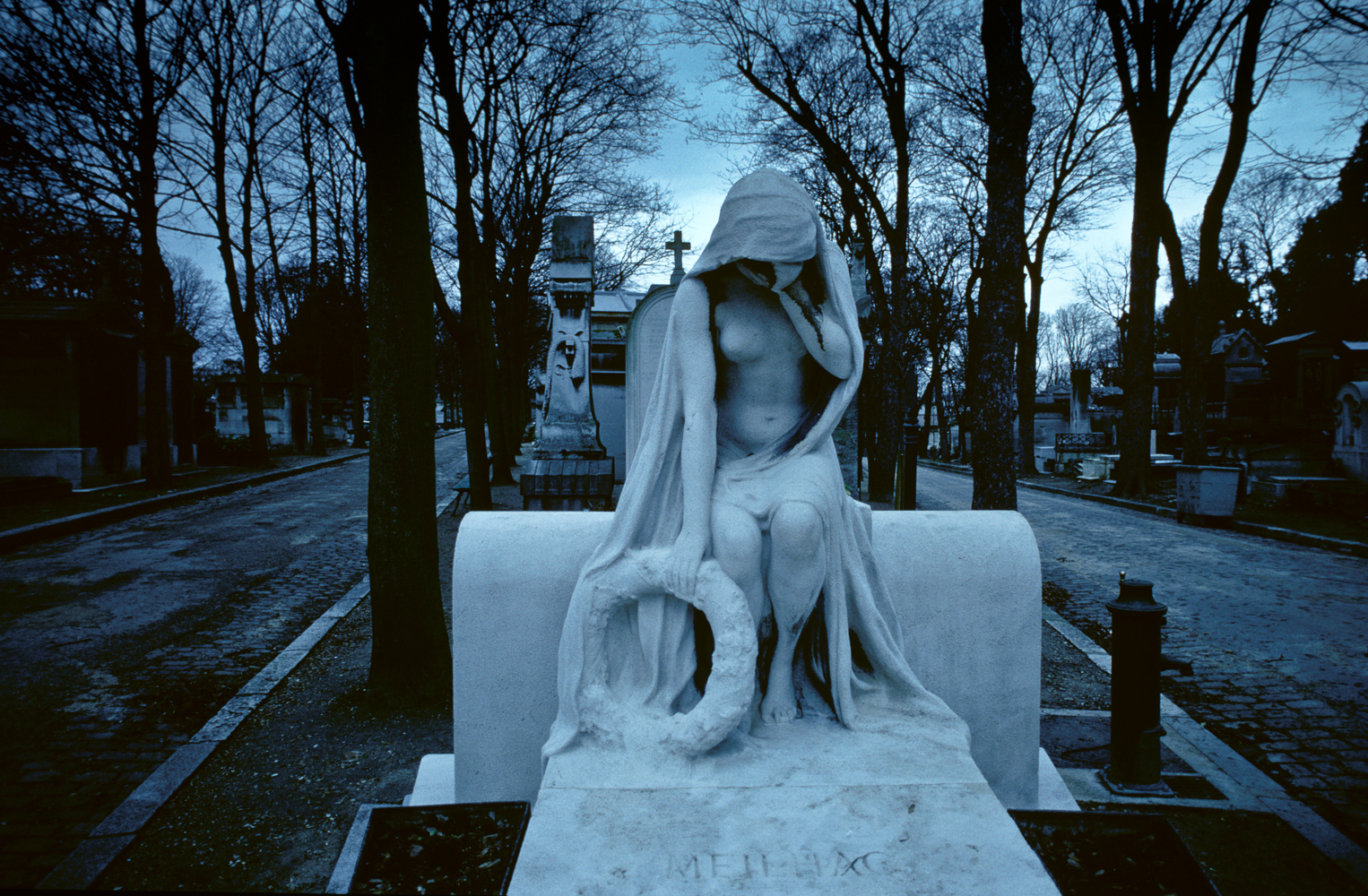 A statue of a hooded woman on a tomb in Paris' Père Lachaise cemetery.