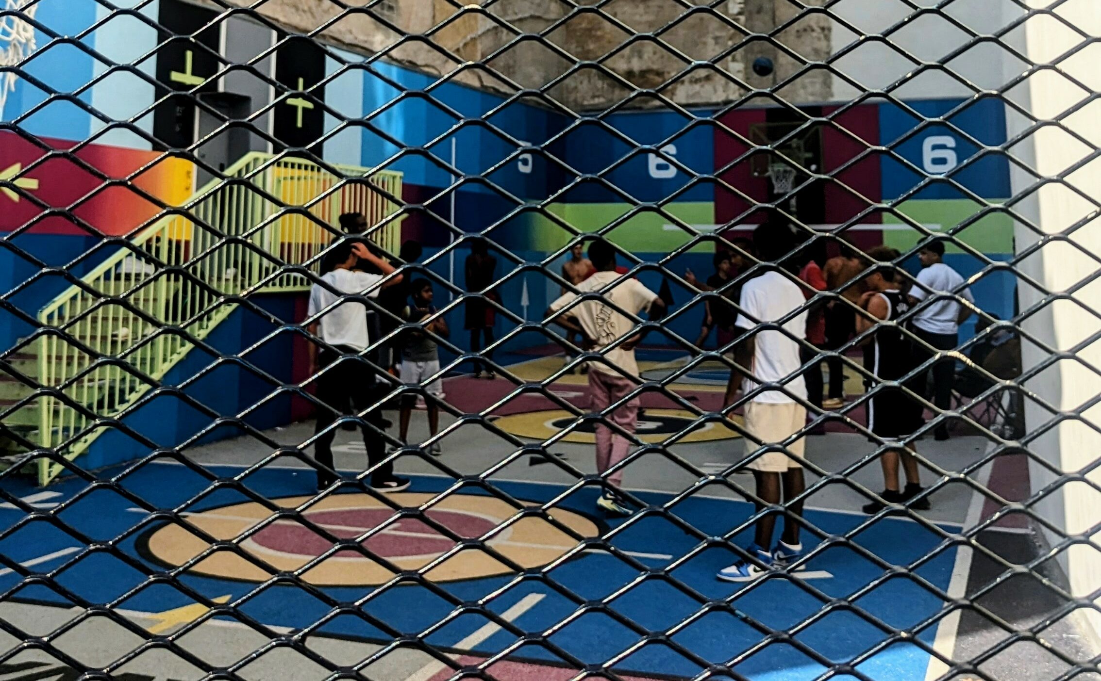 Local youths playing basketball on the colorful court in the 9th arrondissement in Paris.