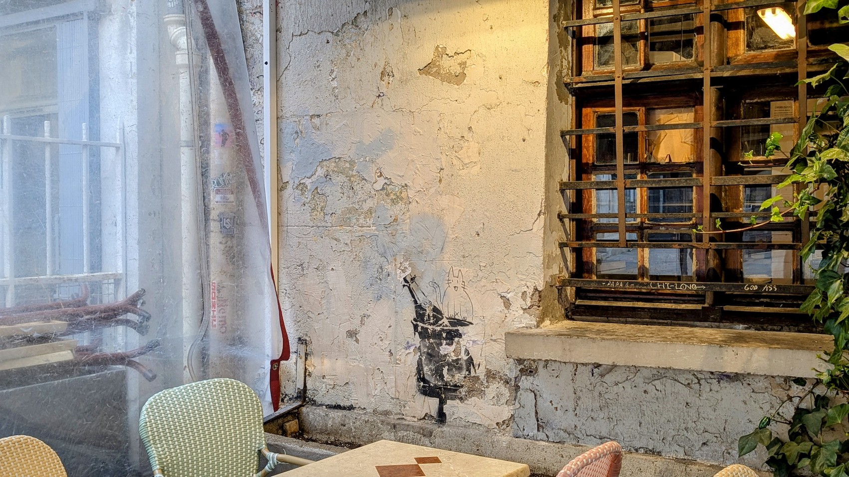 The open champagne bottle of Banksy's Champagne Rat on the crackled walls of the bistro Chez Marianne before the graffiti was destroyed.
