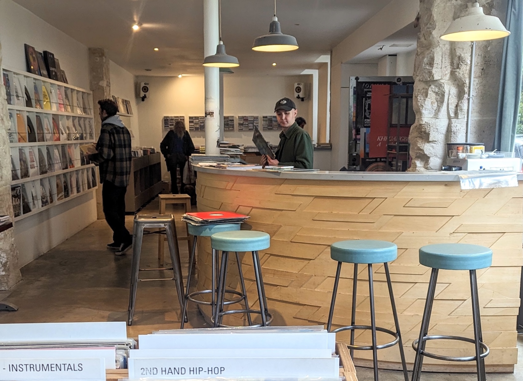 Inside Babaluma record store in Paris: the wooden coffee bar is in the middle of the store.