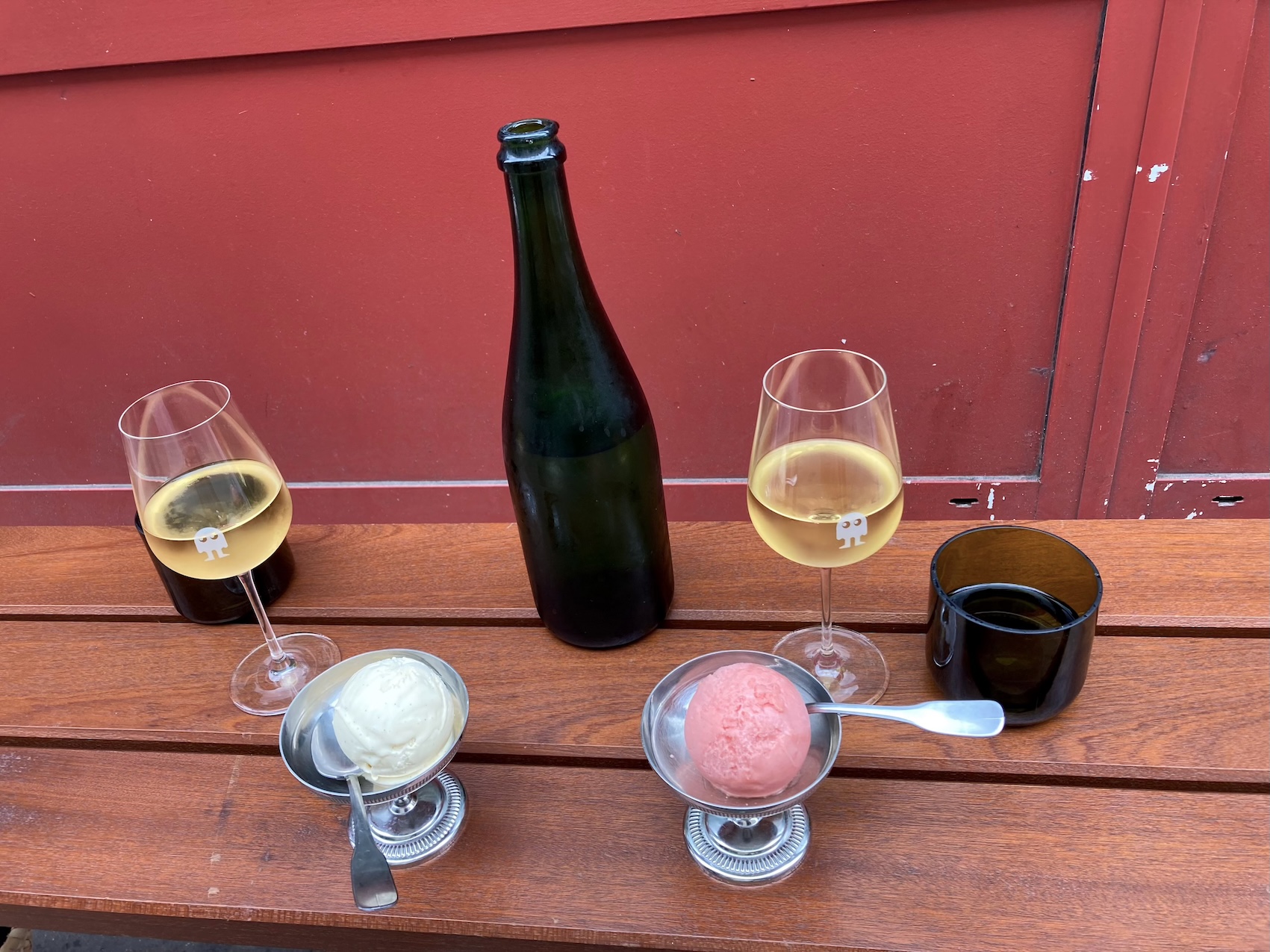 Wine and ice cream set up on a bench in front of Folderol in Paris