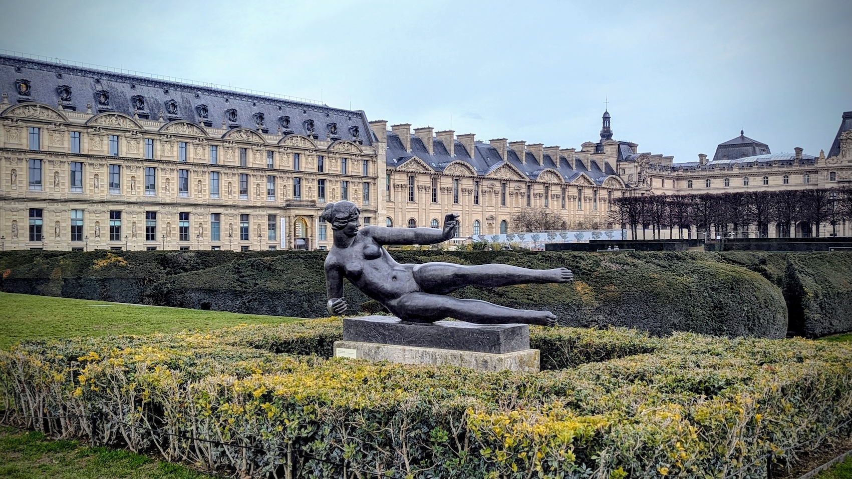 A statue of a female nude by Aristide Maillol in the Tuileries Garden in front of the Louvre.