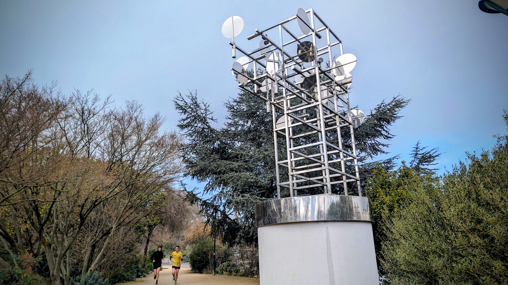 Two joggers running by a sculpture in the Musée de la Sculpture en Plein Air in Paris